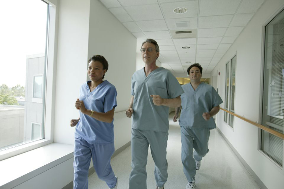picture of three medical providers running through a hallway