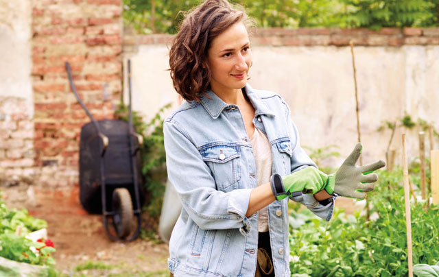 woman putting on gardening gloves