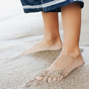 Boy's feet in sand at the beach