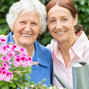 Two women gardening and smiling