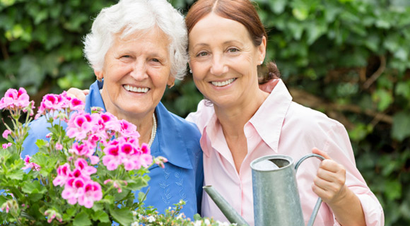Senior woman and middle-aged woman gardening and smiling