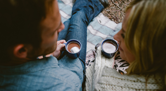 Couple gazing at each other while drinking hot chocolate