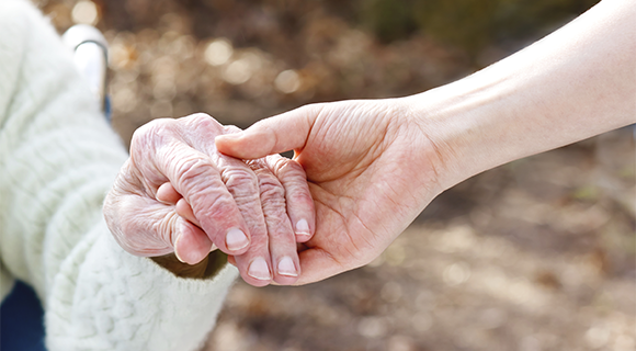 Woman holding an older person's hand